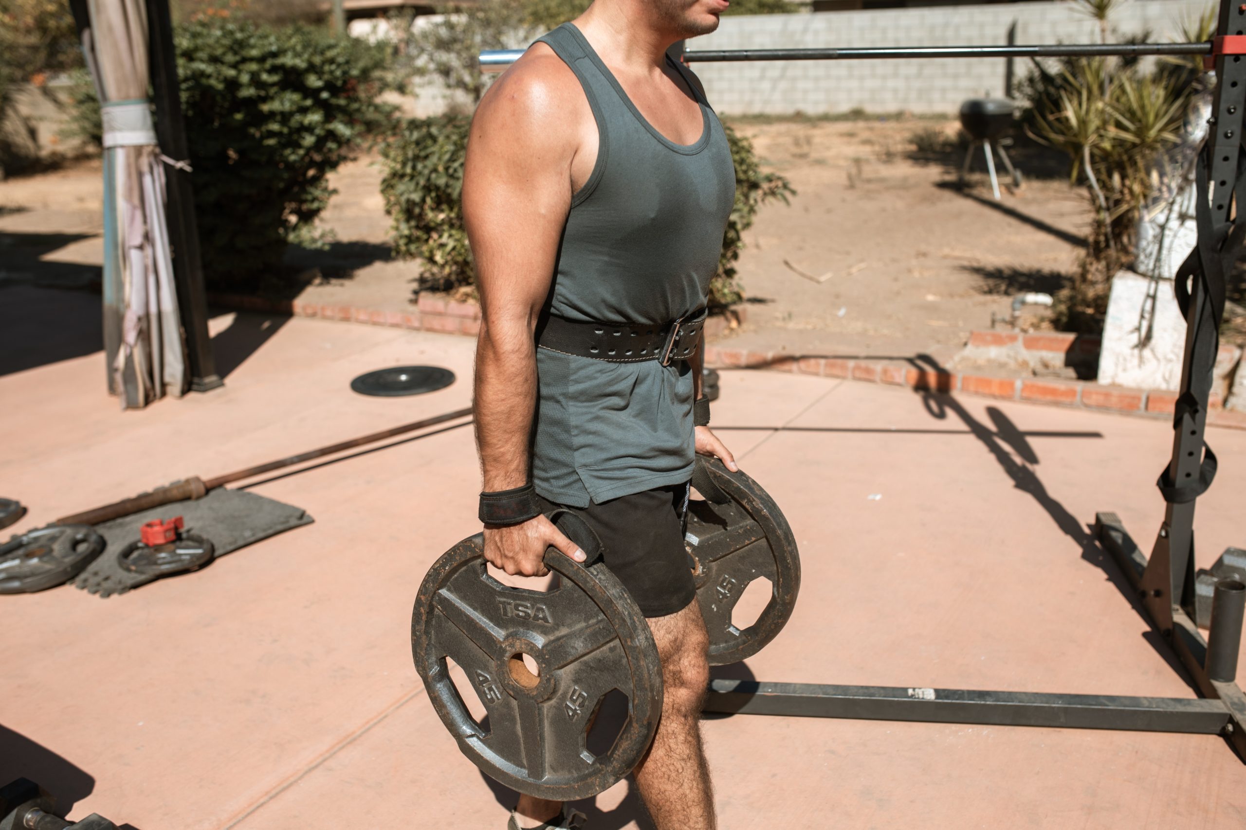 A man holding two plates on both his hands doing powerlifting training