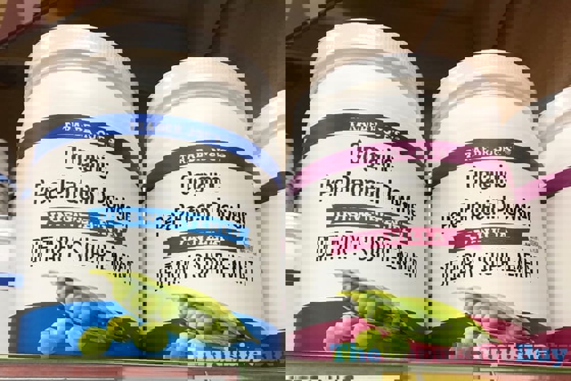 Two huge white bottles of Trader Joe's Organic Pea Protein Powder in different flavors