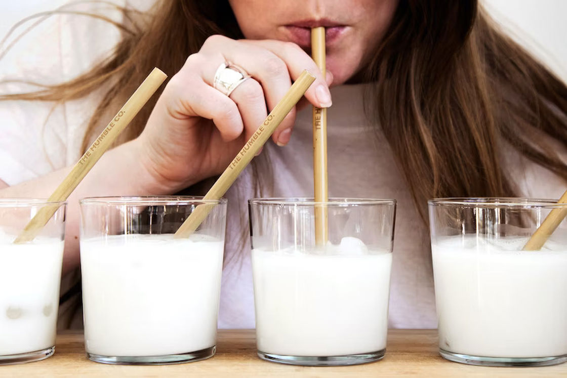 Woman drinking from one of the four glasses filled with supplement drink