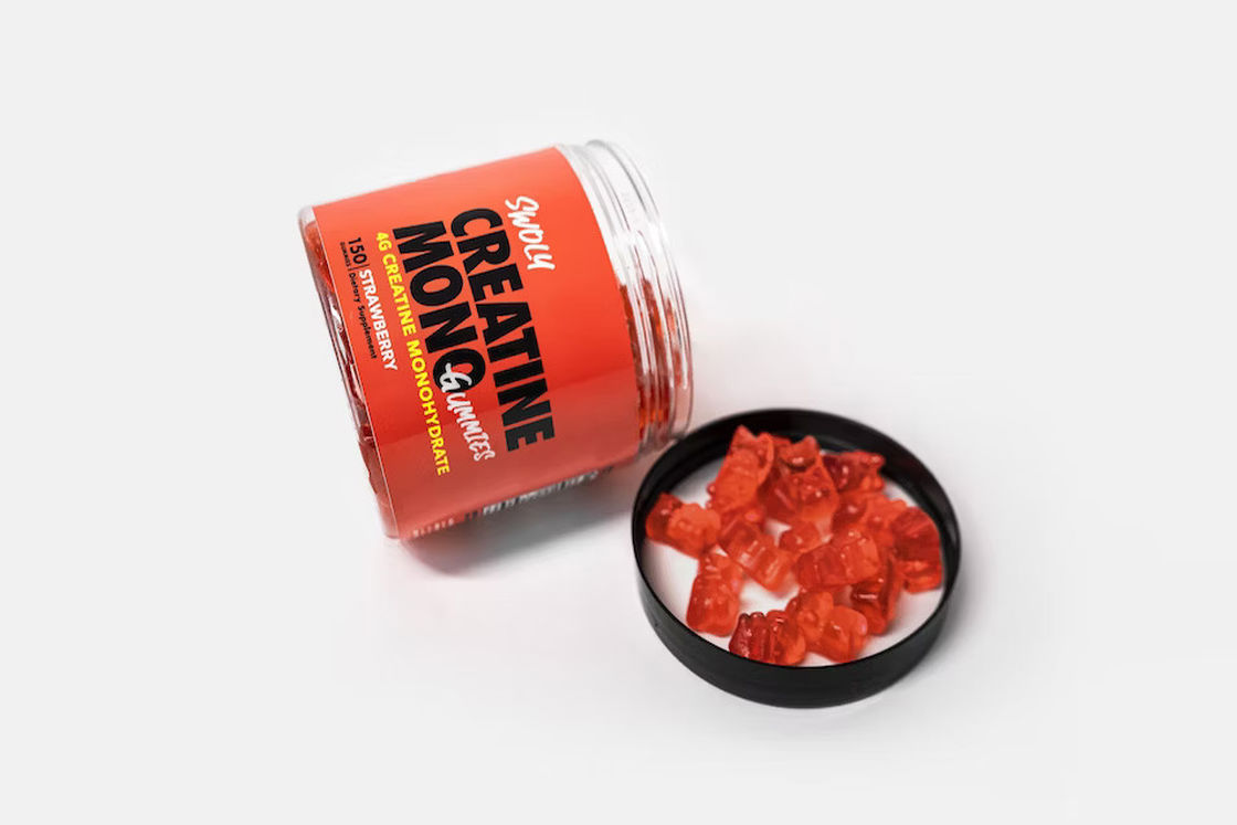 Creatine mono in red gummies placed on the open lid of a bottle