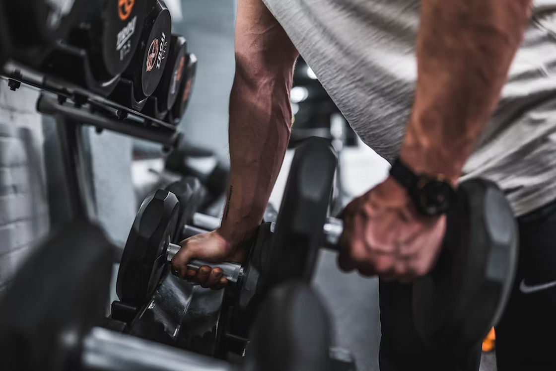 Man lifting dumbbells from a rack