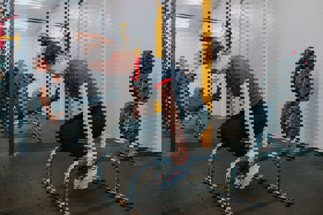 Woman lifting her whole body up on a gym equipment