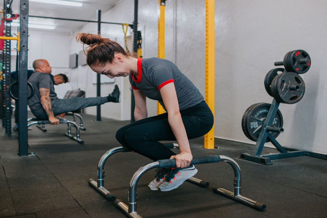 Woman lifting her whole body up on a gym equipment