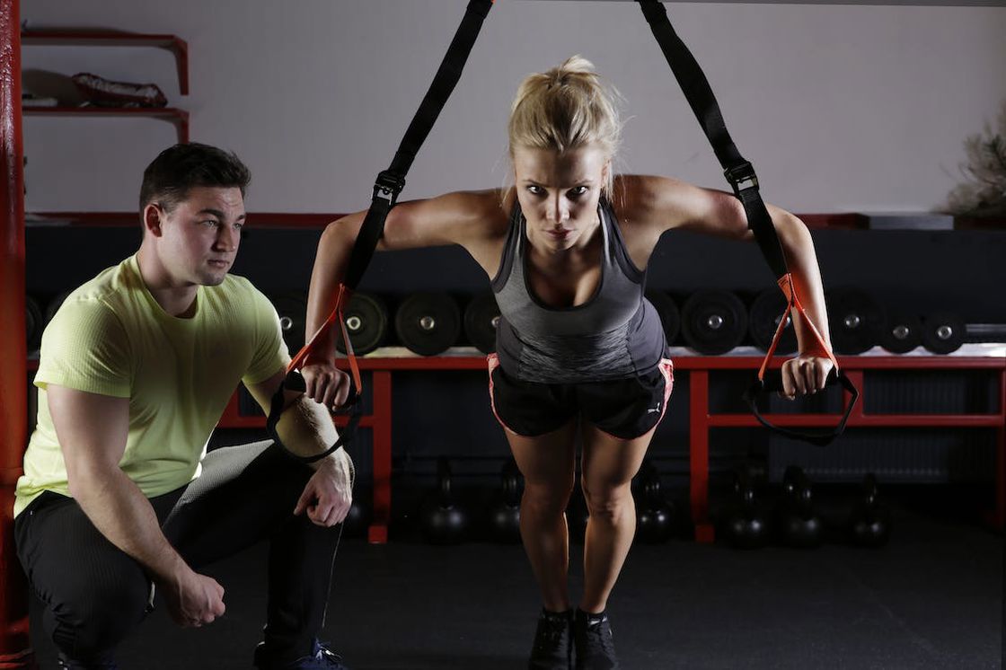 Trainer guiding a woman as she works out