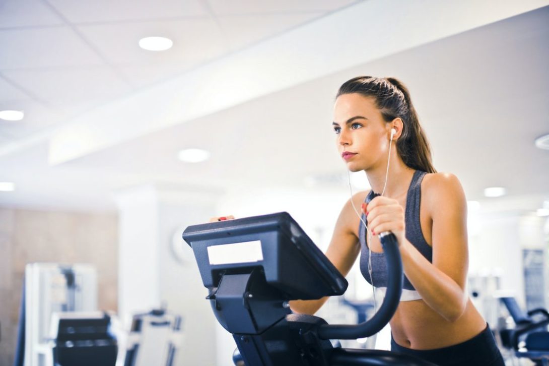 Woman with white earphones while doing cardio workouts