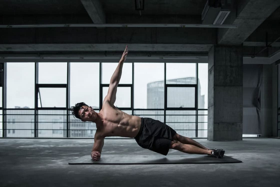 Man doing a side yoga pose in a mat