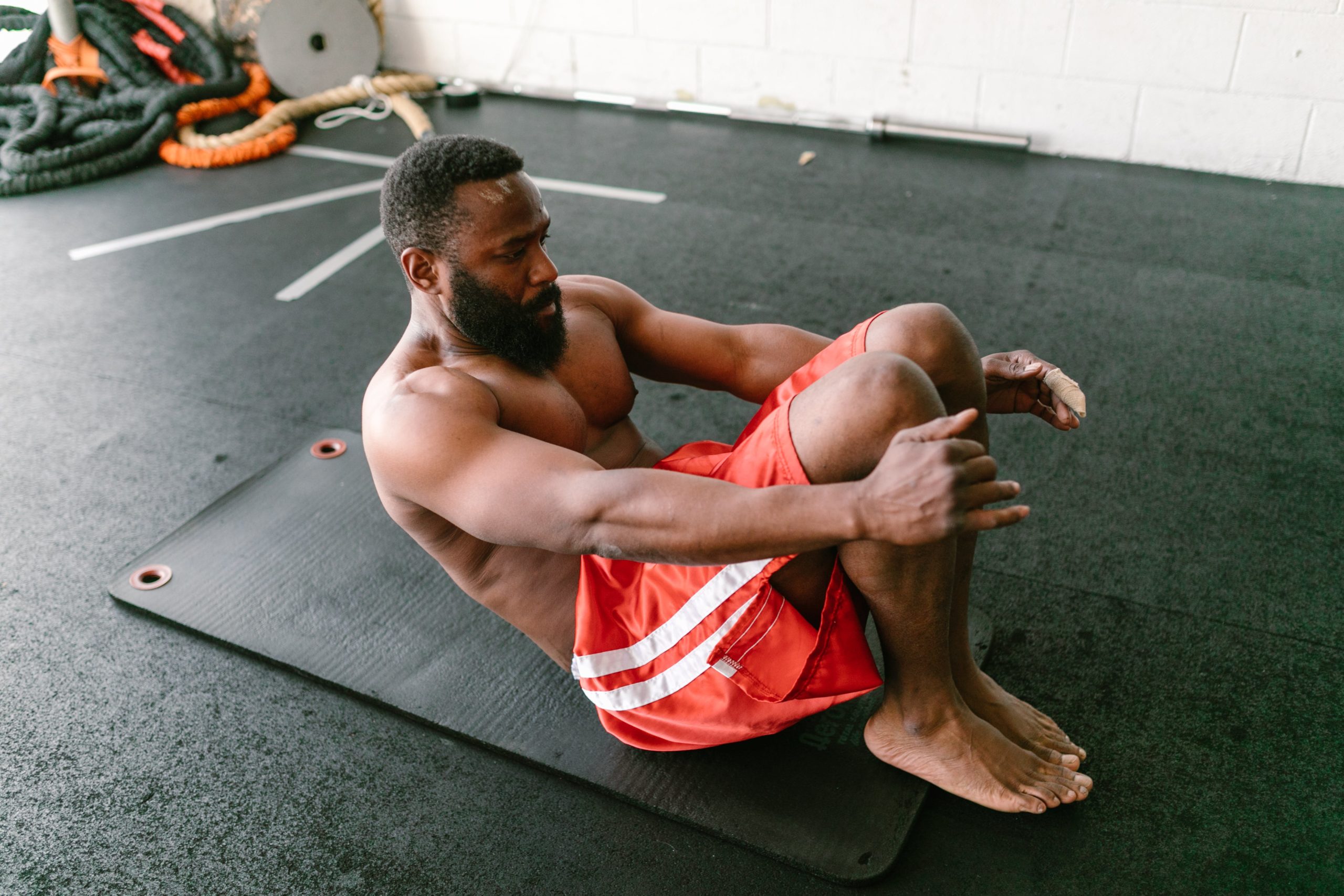 A man exercising on a black mat