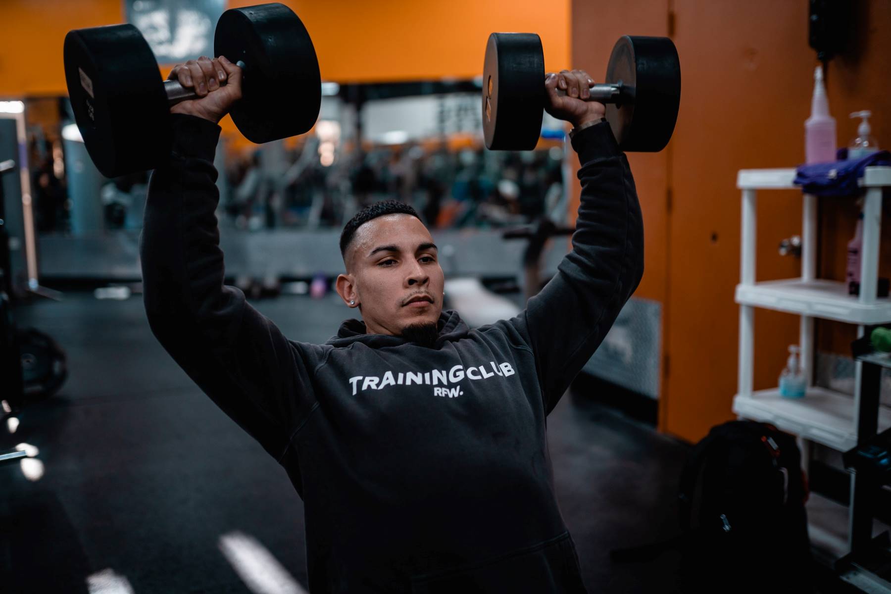 Man in gym doing inclined dumbbell press