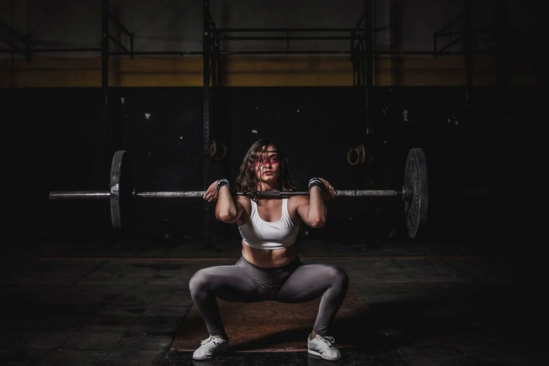 Woman lifting a barbell and resting the weight on her shoulders