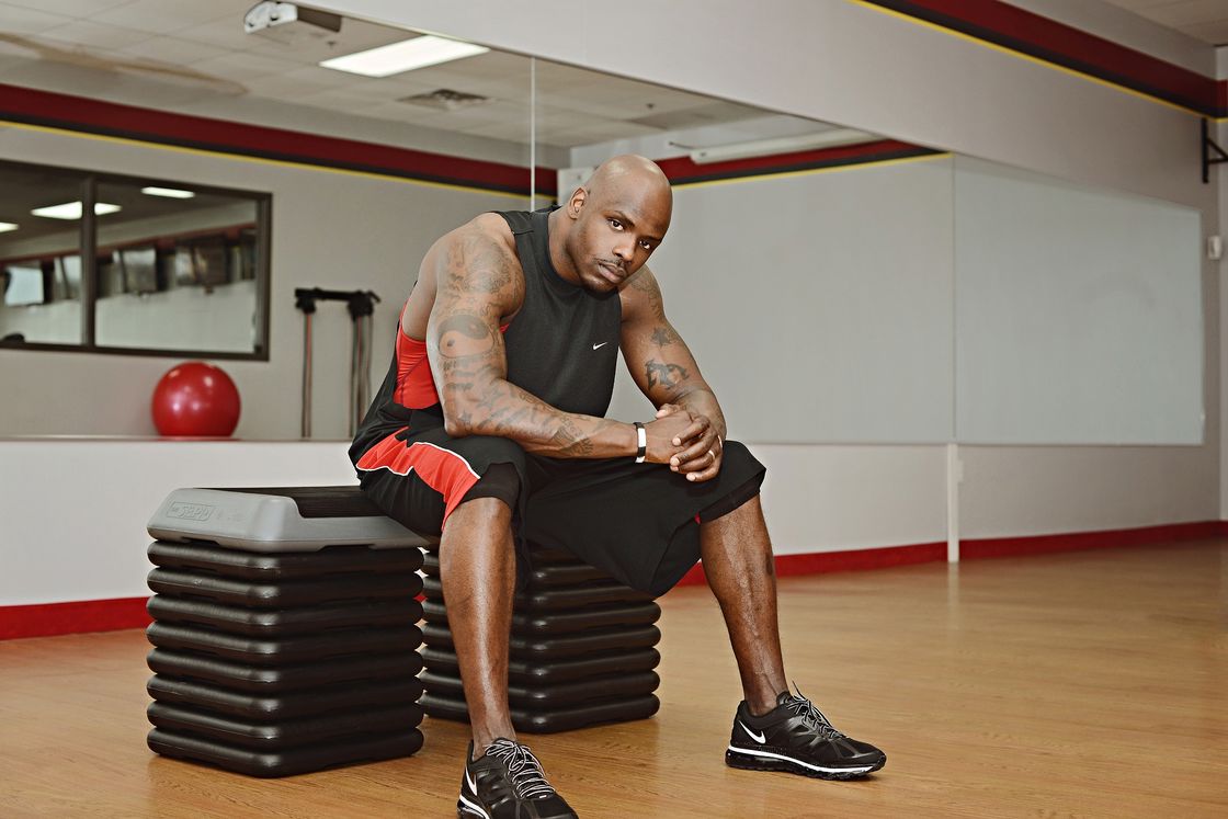 Man sitting down on an equipment while inside a gym