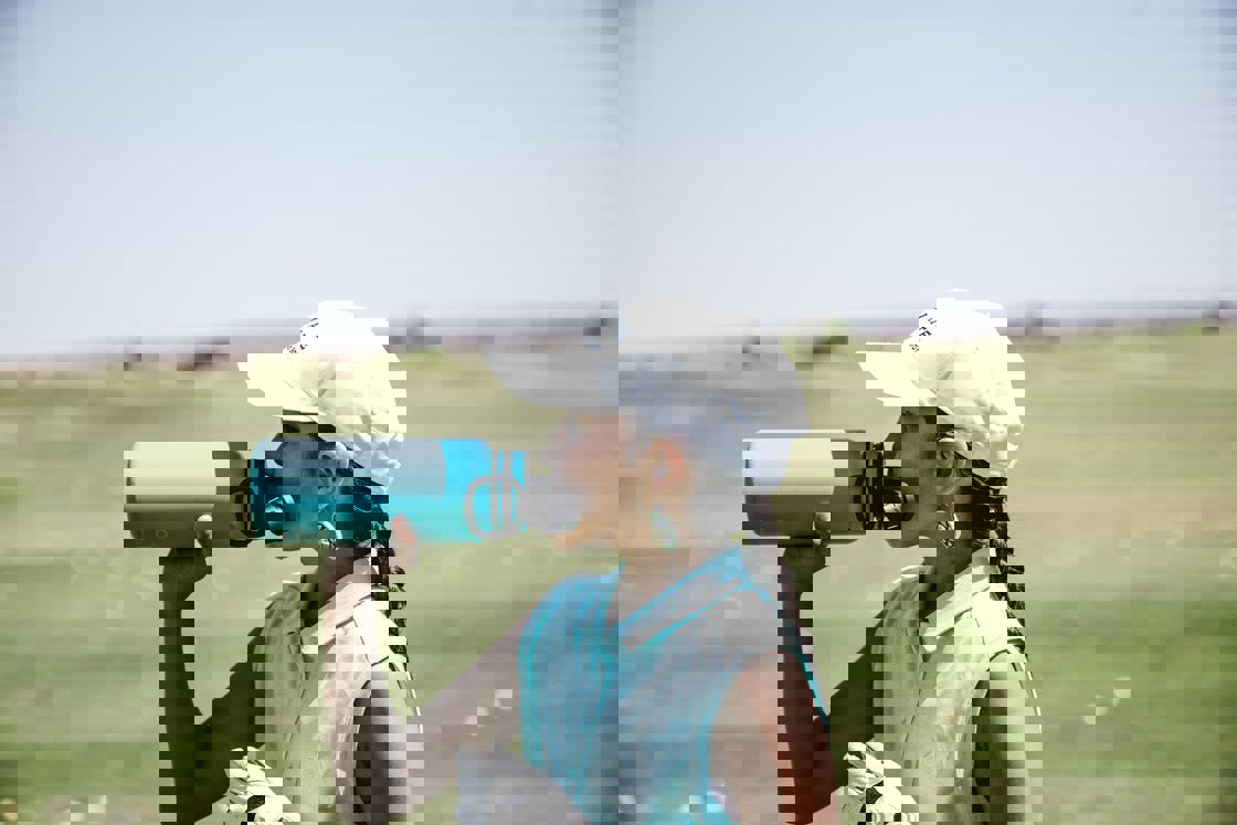 Woman drinking from an aqua green water bottle