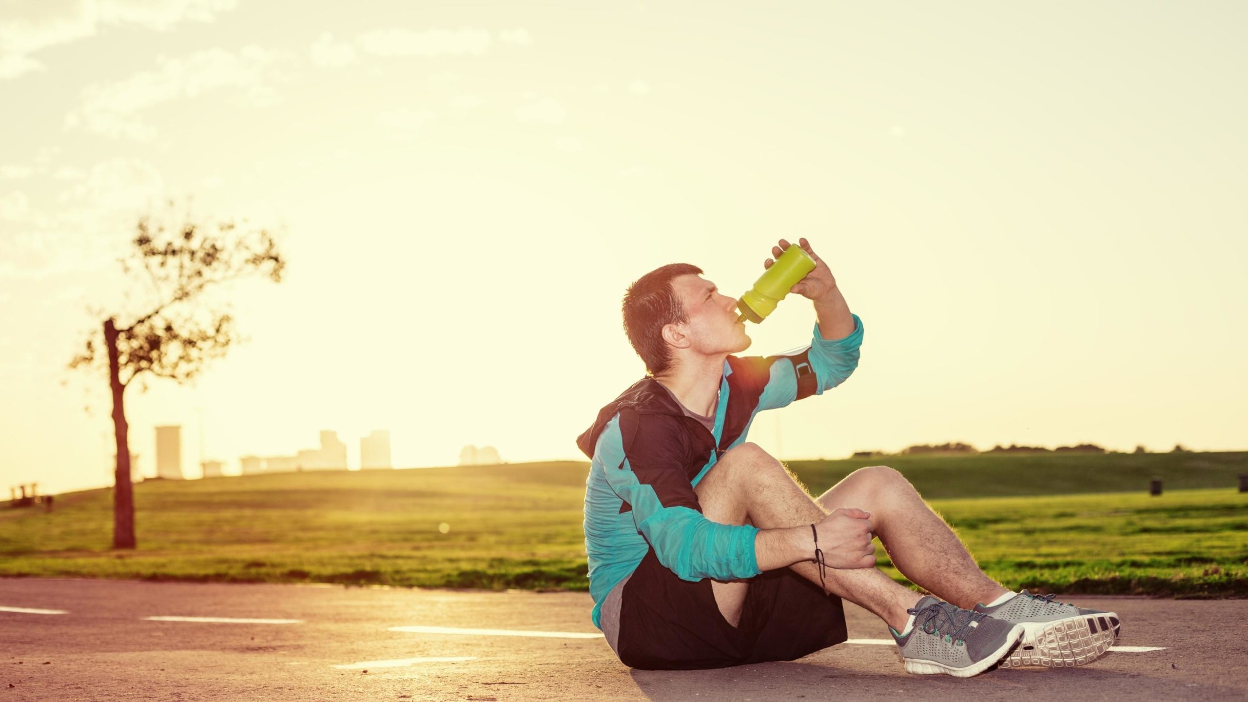 runner pausing to drink electrolyte drink